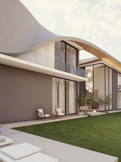 A view of a modern residence with a gently curving roofline that extends over a large lawn. The design emphasizes horizontal lines and a connection to the landscape, with an outdoor lounge area for enjoying the surroundings.