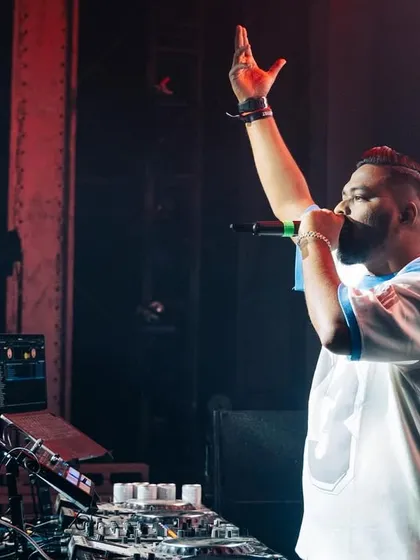 One hand raised, calling for more energy from the crowd. I feed off the vibe they give me.