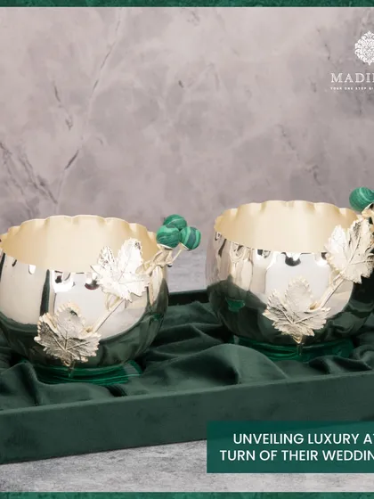 A pair of silver-plated bowls from the Malachite Collection, featuring delicate leaf and malachite berry details. These pieces are designed to unveil luxury at every turn of a wedding tale.