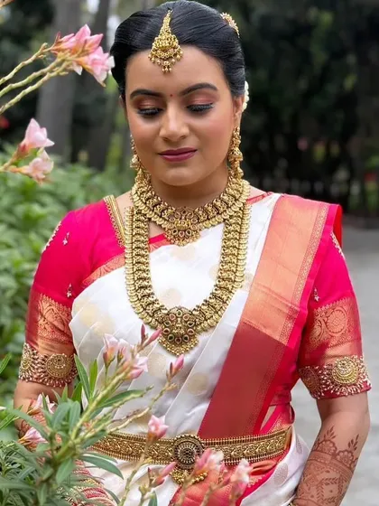 A closer look at the beautiful details. This image shows the texture and craftsmanship of the antique-finish Kasu haram and choker, a popular choice for traditional ceremonies.