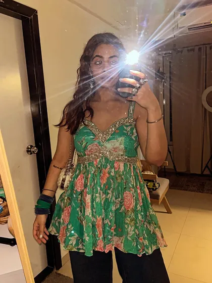 A mirror selfie showing off this gorgeous green floral peplum top. This style is great for pear shapes as it cinches at the waist and flares out over the hips, creating a lovely silhouette.