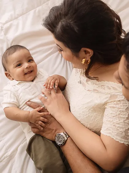 An overhead shot of parents admiring their smiling baby. This perspective offers a unique and intimate view of a family's love.