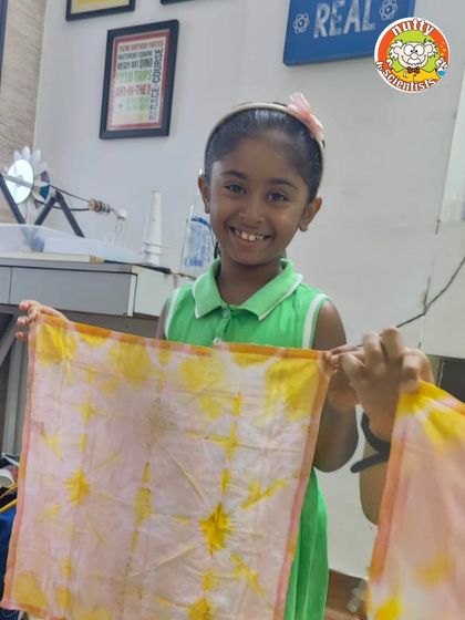 Who needs artificial colors when you have nature's palette? This happy camper is showing off her handkerchief dyed with beetroot and turmeric, a beautiful lesson in natural pigments.
