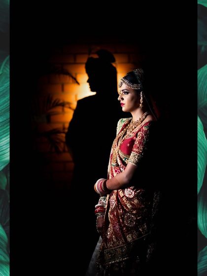 A dramatic bridal portrait using shadow play, with the groom's silhouette cast on the wall behind the beautifully lit bride.