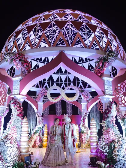 A breathtaking decor structure featuring a massive, intricately designed dome under which the couple stands. This is an example of how I use grand architectural elements to create unforgettable focal points.