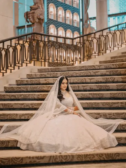 Another angle of this stunning bridal portrait, showcasing the sheer volume and intricate detail of her wedding lehenga.