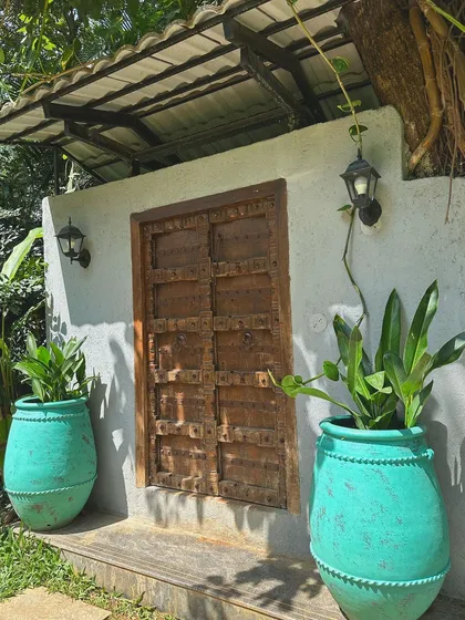 I love the rustic charm of these antique teal 'Ubud' terracotta planters. Here, they frame an old wooden door, showing how a pop of color and handmade texture can bring an entryway to life.