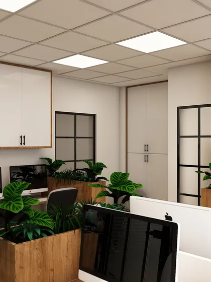 This angle showcases the use of wood and white laminates, creating a warm yet professional feel. The large planters are strategically placed to improve air quality and add a biophilic design element.