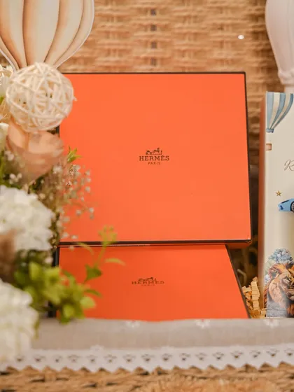 For this special baby announcement, I included iconic orange boxes from Hermès, adding a touch of high-end luxury to the curated hamper and making it an extra special gift for the new parents.