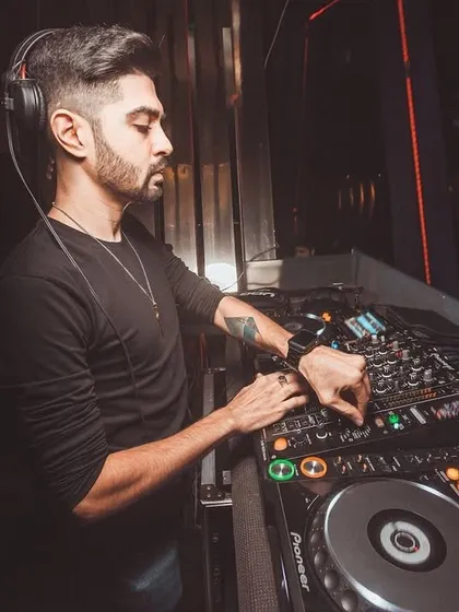 A side-angle shot showing my concentration as I adjust the levels on my mixer. Every track is carefully selected and blended to maintain the flow of the night at a busy club.
