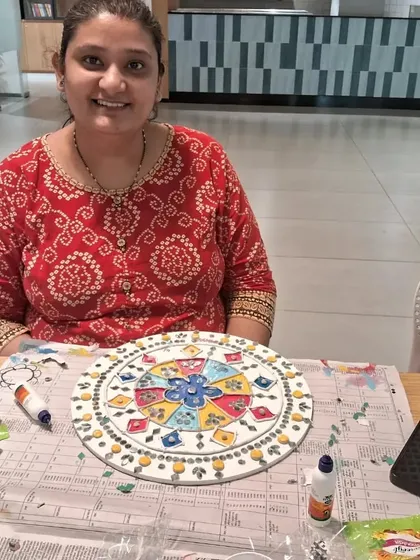 A happy artist with her finished Lippan art piece. The beautiful colors and traditional patterns make for a stunning piece of home decor.