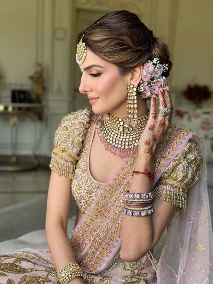 The bride's radiant smile, with her beautiful floral bun adding to the romantic wedding day look.