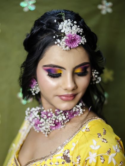 A full view of the Haldi look, with a beautiful braided hairstyle and floral accessories.