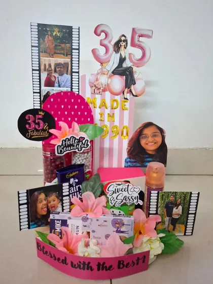 This '35 and Fabulous' birthday hamper is a burst of pink and personality. It includes photo film strips, custom cutouts, and a mix of sweet and savory treats to celebrate a special milestone.