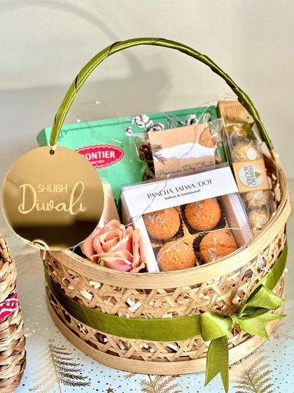 A still shot of our charming bamboo basket hamper for Diwali. The combination of savory snacks, sweet chocolates, and festive candles makes it a well-rounded and delightful gift for anyone.
