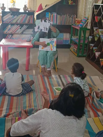 Using a paper cutout, the storyteller demonstrates how the chameleon changes. These simple props make the story more tangible and memorable for the kids.