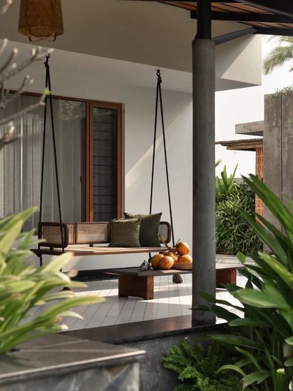 A beautiful wooden swing on the verandah, surrounded by tropical plants, offers a perfect spot to enjoy the Chennai climate.