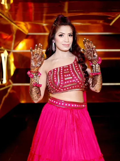 A happy and welcoming pose from the bride, showcasing her beautiful smile and her stunning Mehndi.