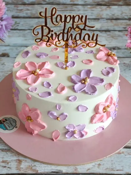 A simple and pretty birthday cake with hand-piped pastel flowers. This minimalist design is perfect for a chic and understated celebration.