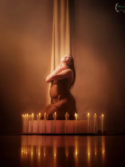 A powerful and spiritual-feeling portrait, with the mother-to-be surrounded by a circle of candles.