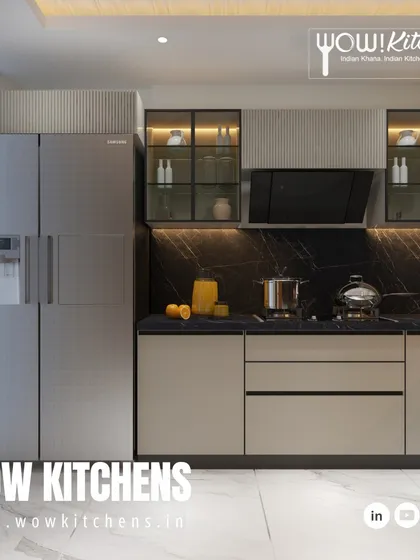 This modern kitchen design uses a harmonious blend of black marble backsplash, beige handleless cabinets, and glass-fronted upper cabinets to create a look of understated elegance.