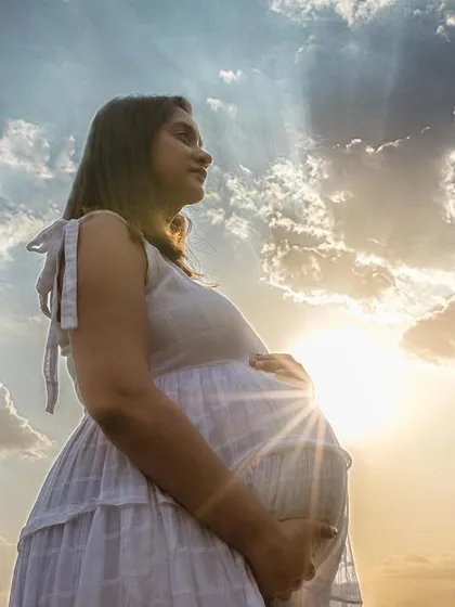 A powerful and dramatic maternity silhouette against a beautiful sky. The sunburst behind the baby bump symbolizes the light and life of the new beginning.