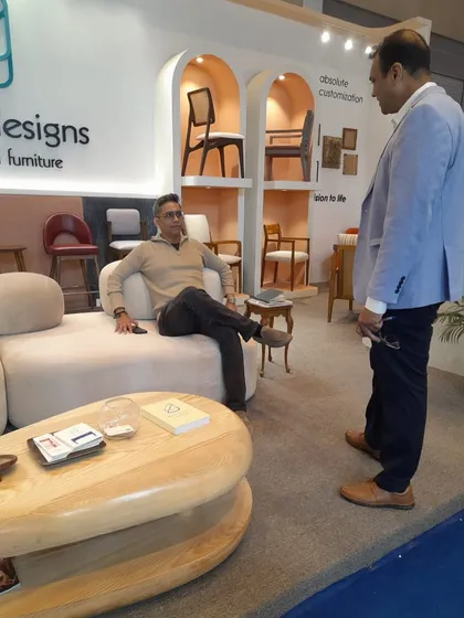 Discussing the finer points of a chair design with a visitor at our stall. I enjoy sharing the story behind each piece and the craftsmanship that goes into it.