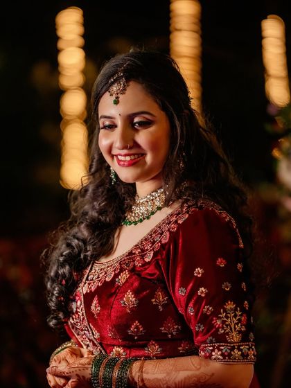 A close-up of Sheetal's reception look. The warm lighting highlights the glow of her skin and the richness of her outfit.