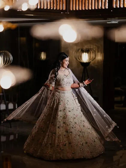 A beautiful full-length portrait of the bride twirling in her stunning Sangeet lehenga. The soft lighting and her joyful expression perfectly capture the elegance and happiness of the evening.