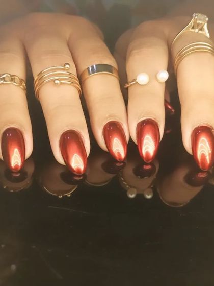 A stunning set of deep red cat-eye nails on almond-shaped extensions.