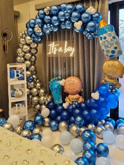 This is an example of my "It's a boy" baby shower decoration. I used a blue and silver chrome balloon arch, transparent "BABY" boxes, and special foil balloons to create a full and festive look for the celebration.