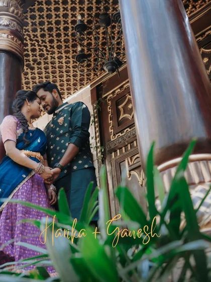 A low-angle shot that uses the grand pillars of a heritage building to frame the couple's intimate moment, highlighting both the architecture and their love.