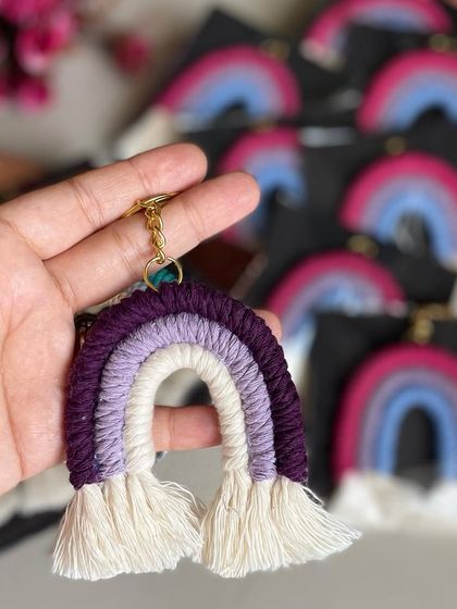 A purple rainbow keychain held in hand. I love this color combination.