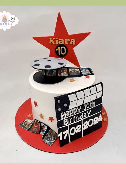 A movie-themed cake for Kiara's 10th birthday, complete with a film reel, a clapperboard, and a big red star.