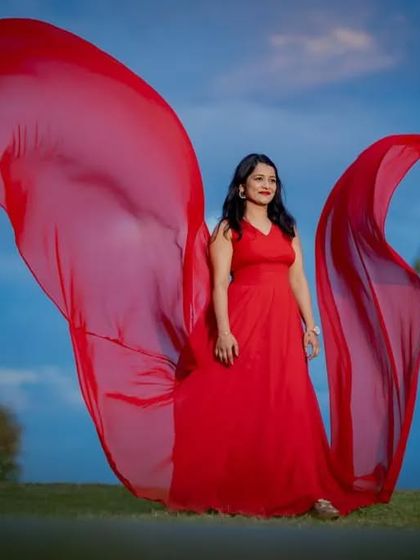 The sheer power of a flying gown. This red dress with its long, flowing trail creates a stunning wing-like effect, perfect for dramatic outdoor portraits.