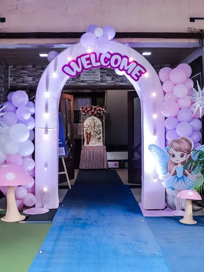 The entrance to Freya's Wonderland party, with a light-up inflatable arch, pastel balloon columns, and fairy-themed props.