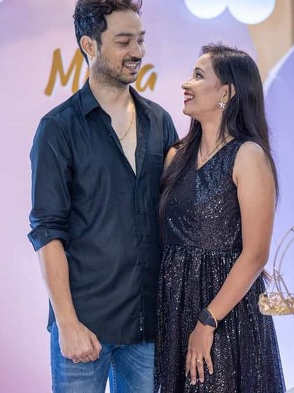 A candid shot of the parents sharing a happy moment during their daughter's birthday celebration.