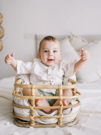 A seven-month-old boy giving a big thumbs-up. He's already a pro at photoshoots, this being his third session with me.