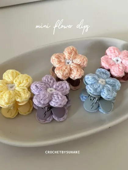 These are my mini flower clips, perfect for adding a pop of color. Each one is handmade and attached to a snap clip, available in pastel shades like yellow, lavender, peach, blue, and pink. They are great for pinning back bangs or decorating braids.