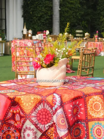 A close up of the colorful table setting from the Banaras themed event, featuring patterned linens and unique floral vases.