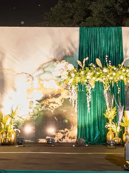 We designed this sophisticated stage for the Inditex corporate Diwali party. The setup features a custom-printed backdrop with marble and gold textures, elegant green draping, and lush floral arrangements, creating a luxurious and festive focal point for the evening's events.