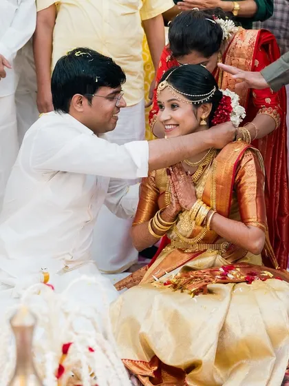 A sacred moment from a South Indian wedding. The groom places the garland on his bride, a simple act filled with tradition and the promise of a new beginning together.