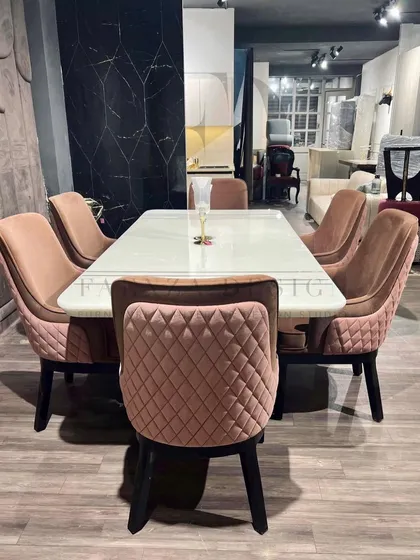 This dining set pairs a white onyx table with diamond-quilted chairs in a dusty rose velvet. The combination of the sleek, modern table and the soft, textured chairs creates a beautifully balanced look.