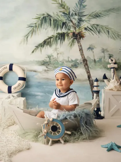 A happy baby boy in a sailor outfit, enjoying his boat during a prop-based photoshoot in my Mumbai studio.