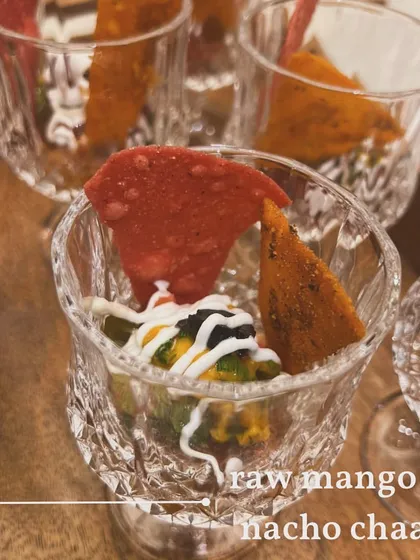 A closer look at the layers in the Raw Mango and Nacho Chaat. You can see the base of tangy salsa, guacamole, and a drizzle of yogurt and sauces.