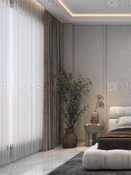 The large window with sheer curtains allows for plenty of natural light, making the neutral-toned room feel bright and airy.