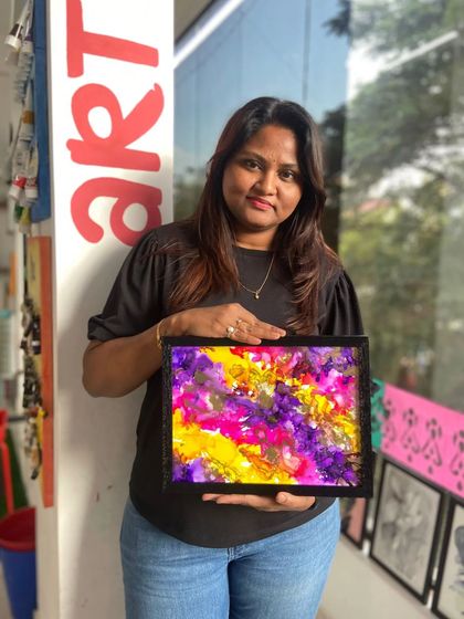 A participant with her vibrant abstract alcohol ink painting. This medium is known for its beautiful, flowing patterns and intense colors.