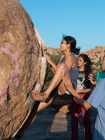 A climber focuses on her move, fully trusting the spotters below her. This is the kind of supportive environment we create at all our events.