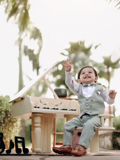 A perfect moment of laughter and play. The combination of the piano, bubbles, and his joyful expression makes this photo truly special.