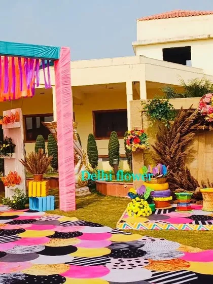 A fun and quirky Haldi carnival theme, featuring a colorful patterned walkway, rustic pampas grass, and playful props.